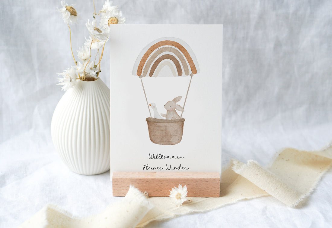 Karte mit Gans und Hase im Regenbogenheißluftballon "Willkommen kleines Wunder"